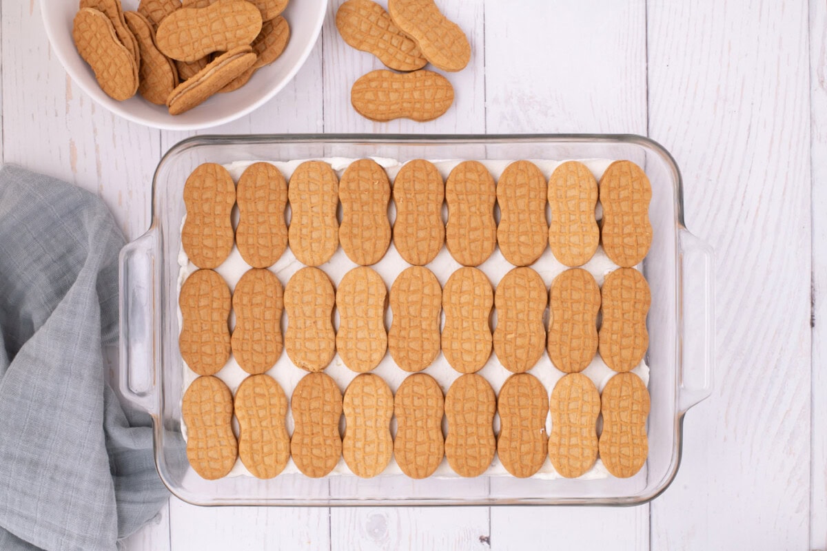 nutter butter cookies in a baking dish on top of whipped cream