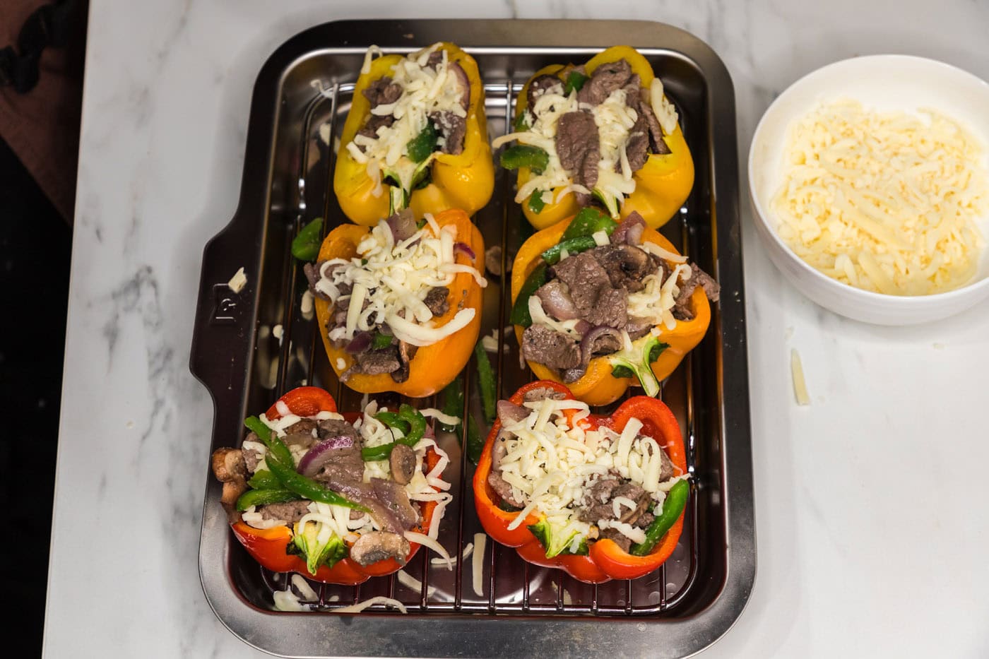 steak and onion mixture added on top of sliced bell peppers with cheese