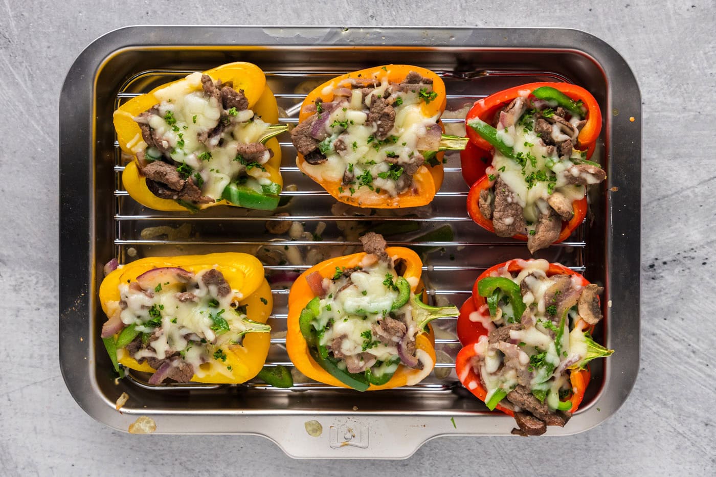 baked overhead shot of philly cheesesteak stuffed peppers in a baking dish