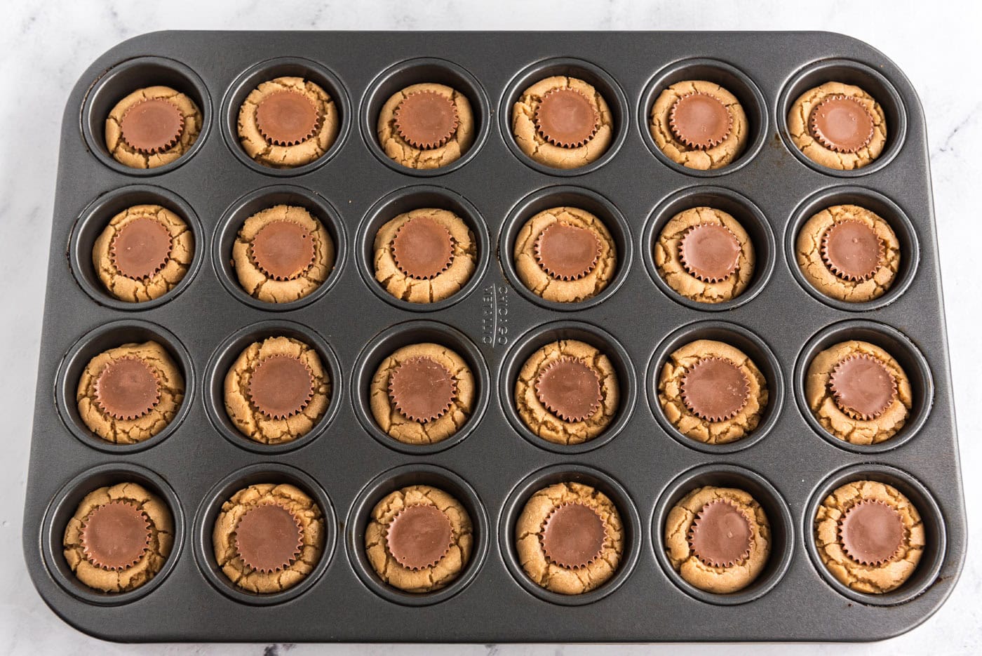 baked reeses peanut butter cup cookies in a mini muffin pan