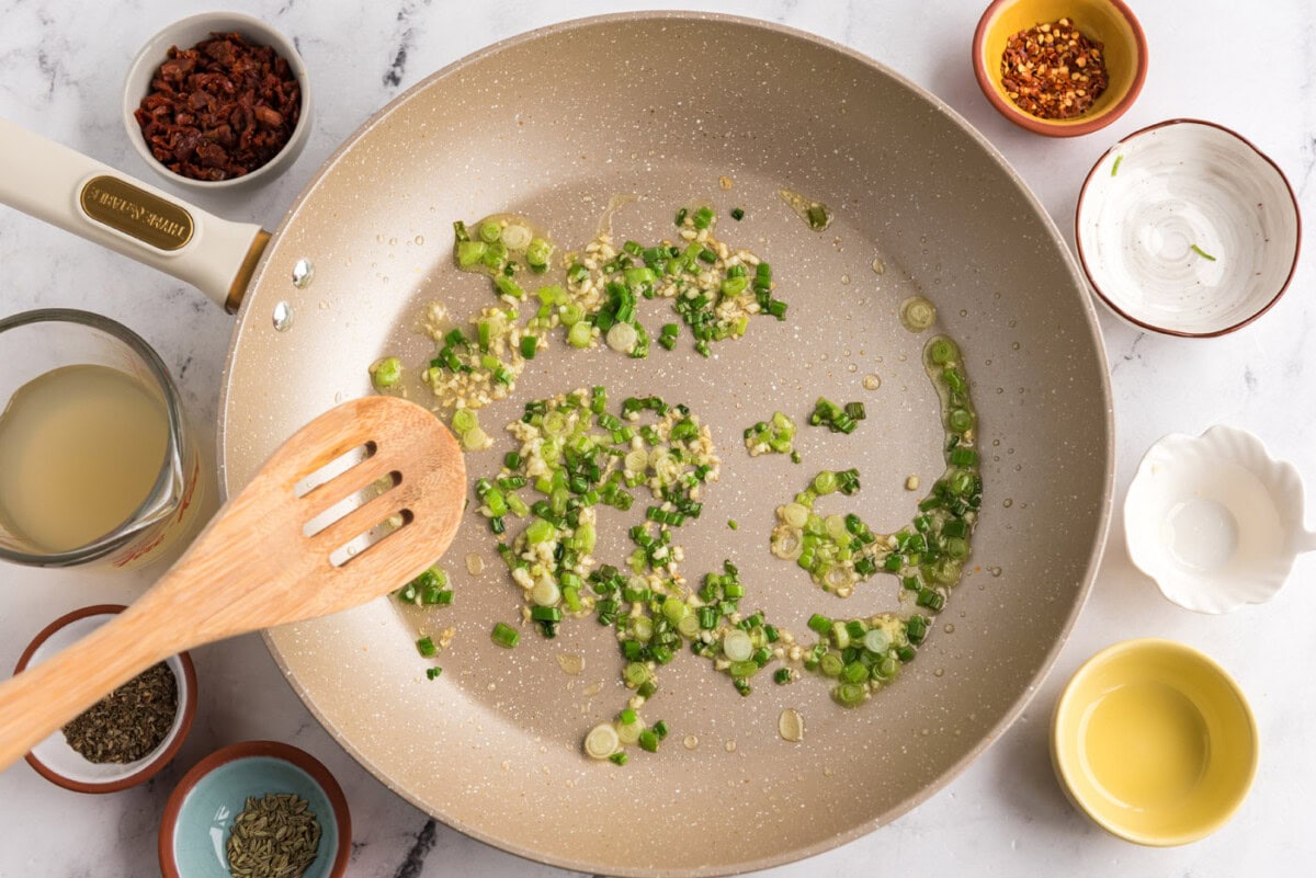 sauteeing garlic and scallions in a skillet
