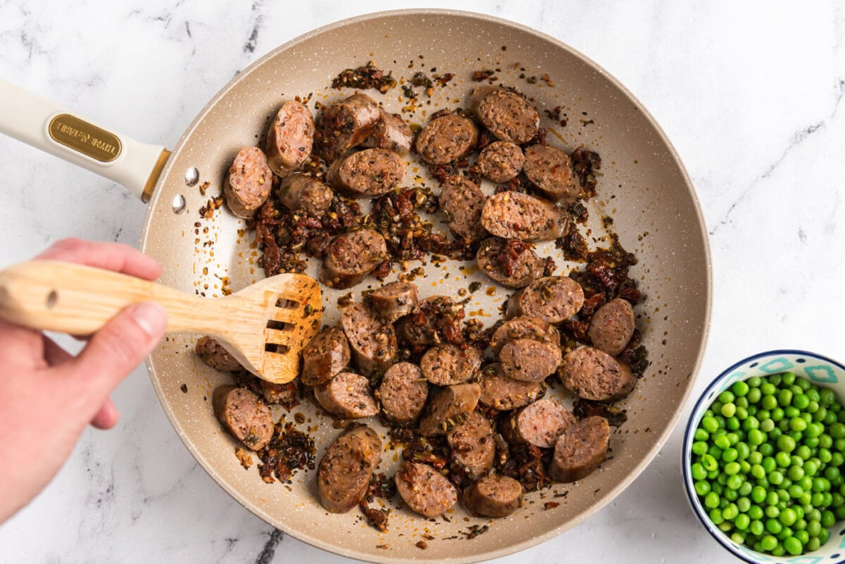 sliced Italian sausage added to skillet with sun dried tomato mixture