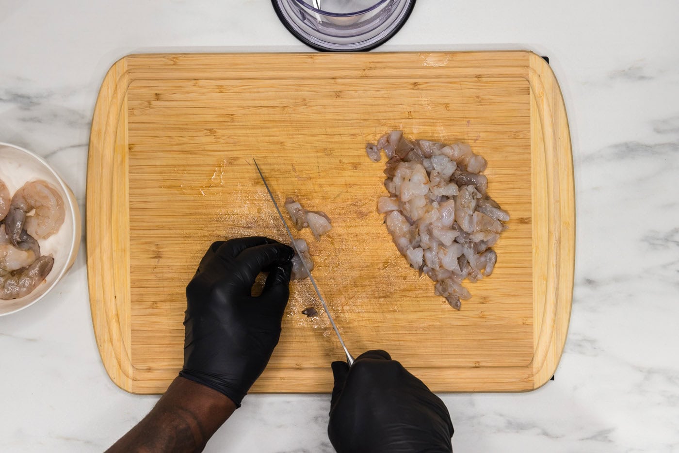 hand chopping raw shrimp