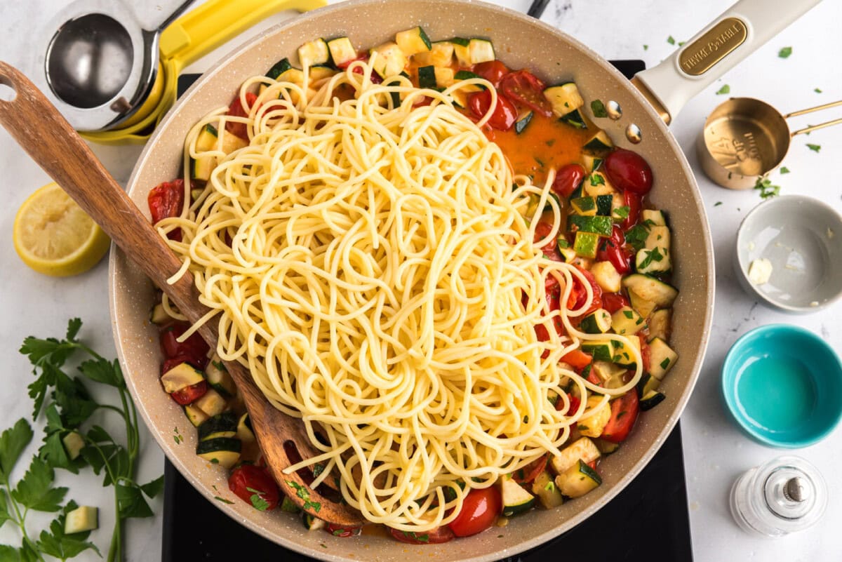 cooked pasta added to skillet with zucchini and tomatoes