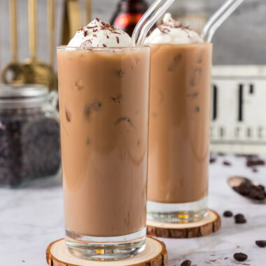 Two Spiked Iced Coffees topped with whipped cream and shaved chocolate