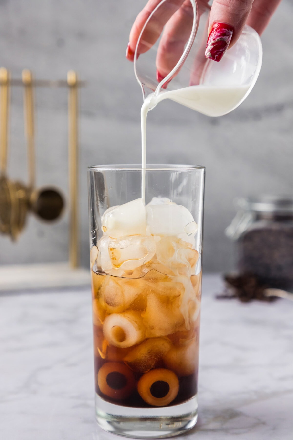 pouring half and half into glass of ice with Kahlua and vodka