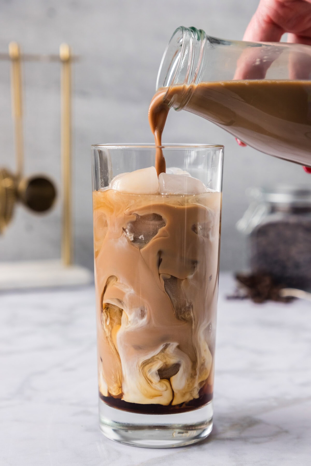 pouring iced coffee into glass of ice with Kahlua and vanilla vodka