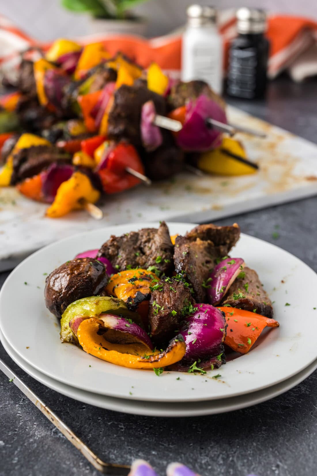 Disassembled Steak Kabob on a plate with more Steak Kabobs in the background