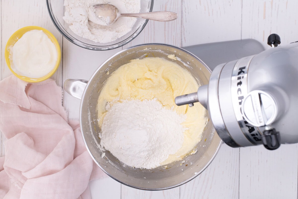 adding flour mixture to wet mixture in stand mixer bowl