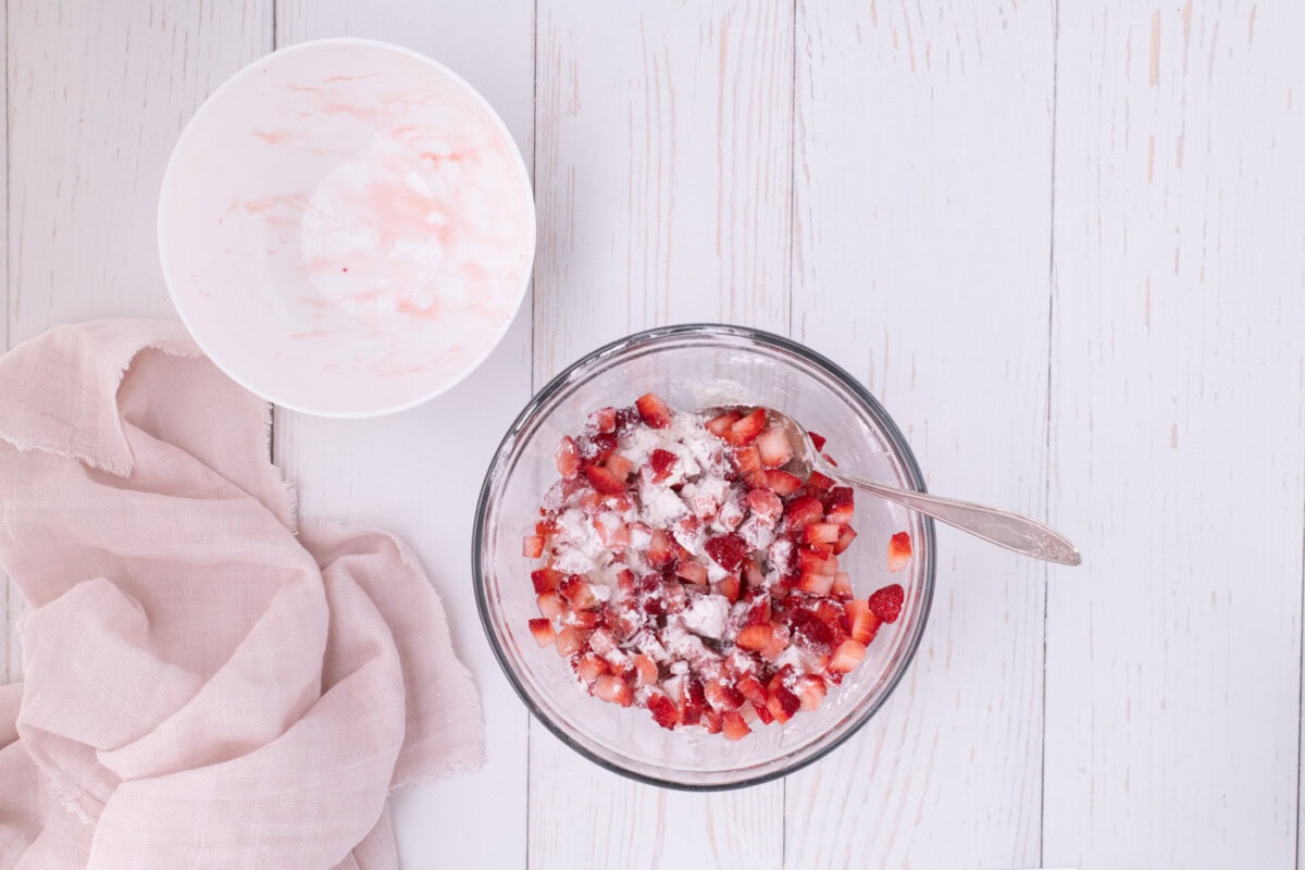slice strawberries with lemon juice and flour in a bowl