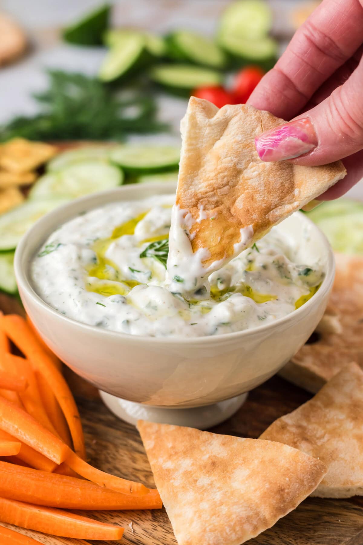 Pita bread being dipped in Tzatziki Sauce