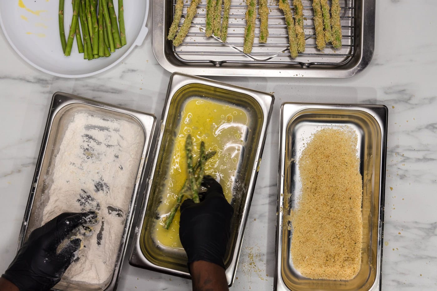 dredging asparagus spears in egg