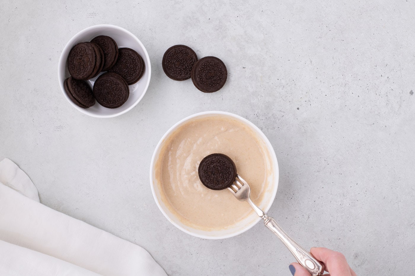 dipping an Oreo into pancake batter with a fork