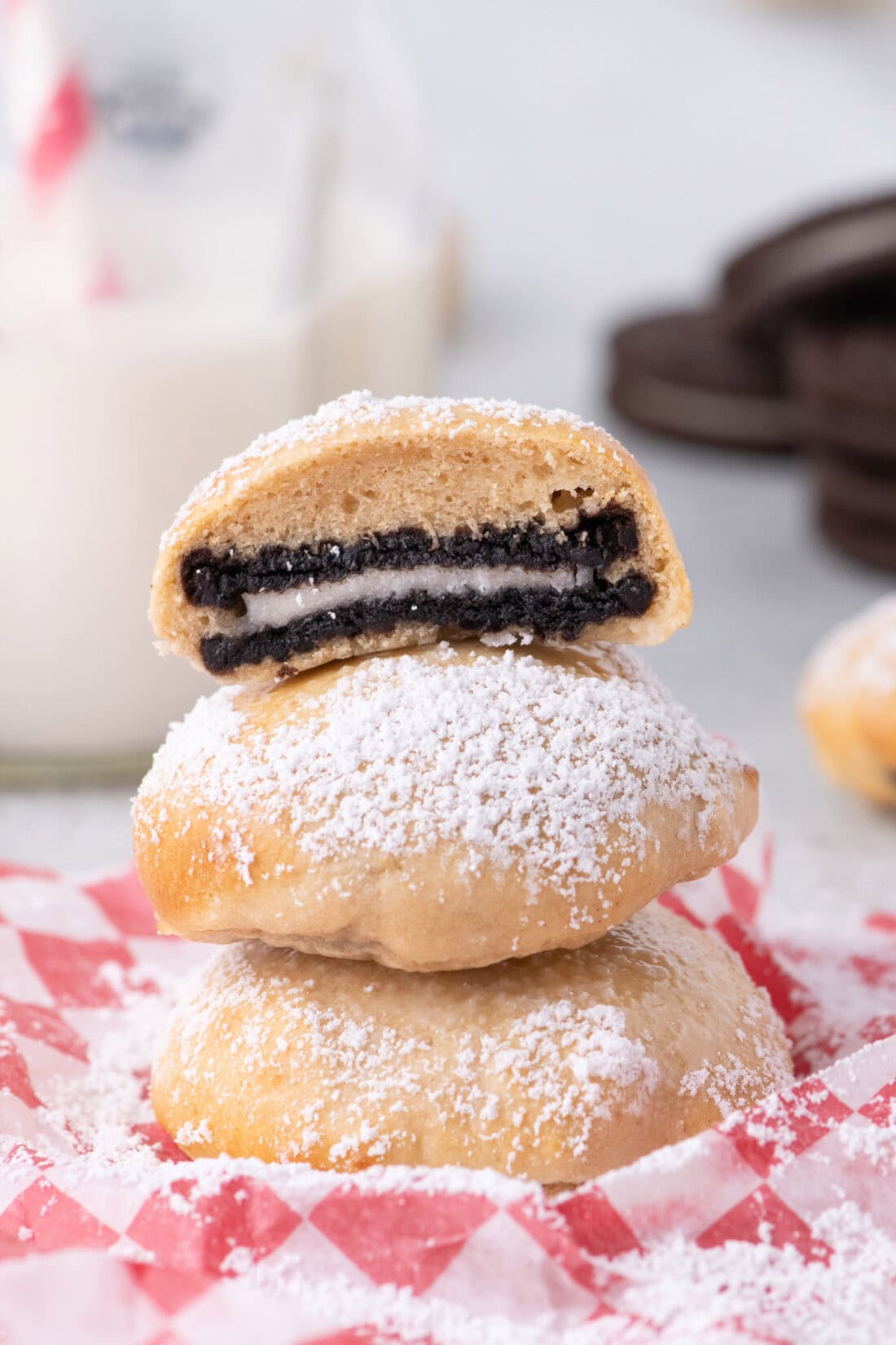 An Air Fryer Oreo cut in half resting on two more Air Fryer Oreos