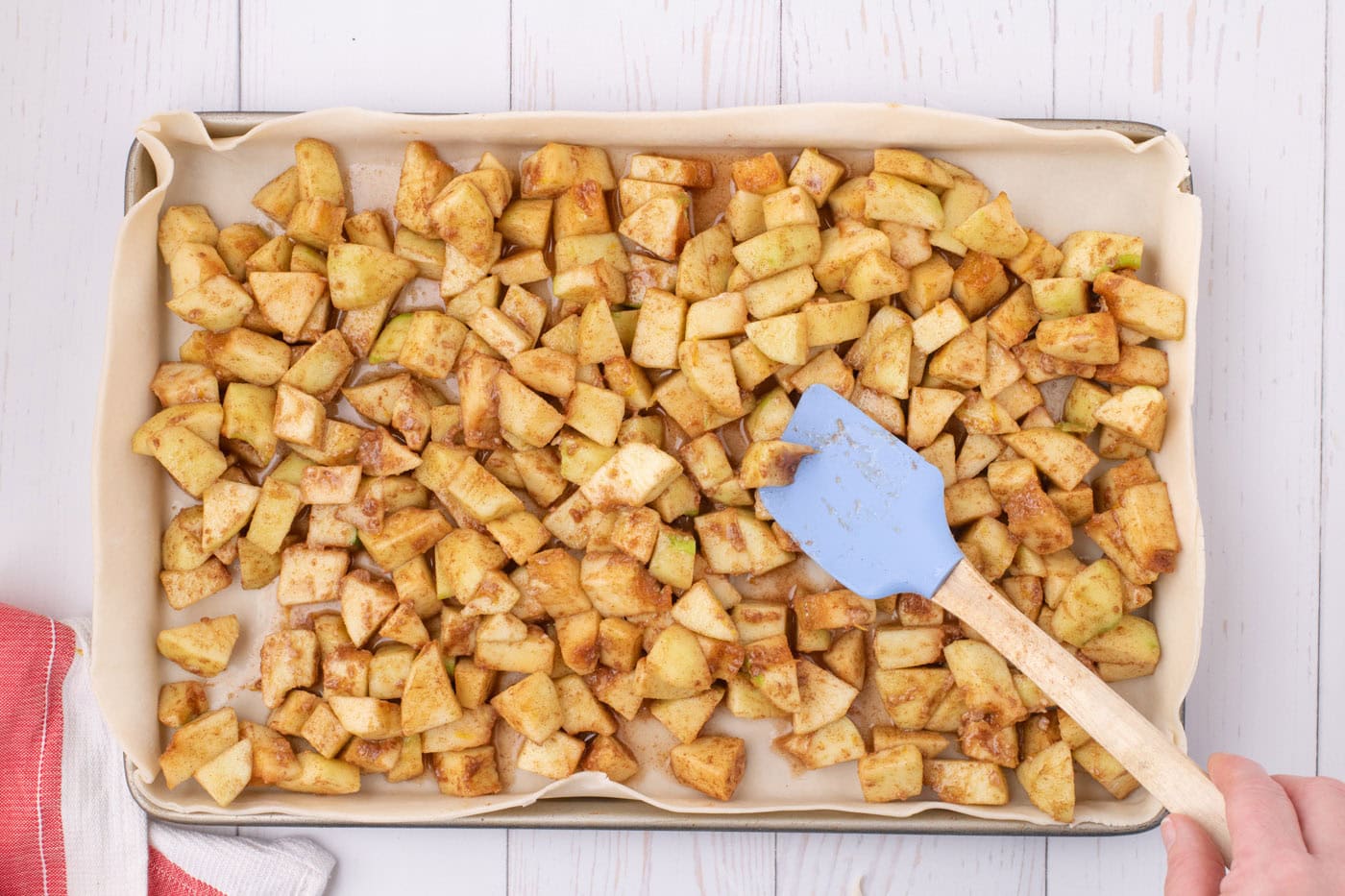 chopped apples added to pie dough in a sheet pan