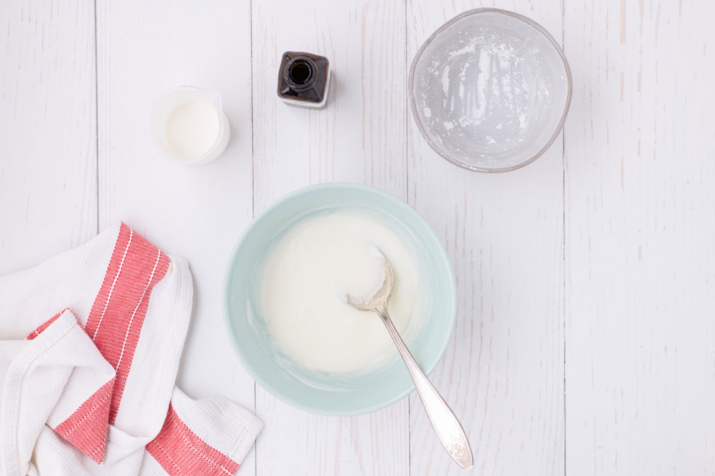 powdered sugar glaze in a bowl with a spoon