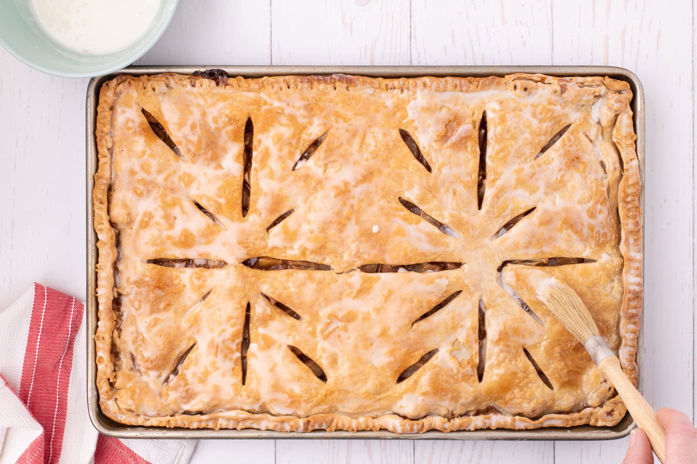 apple slab pie topped with powdered sugar glaze