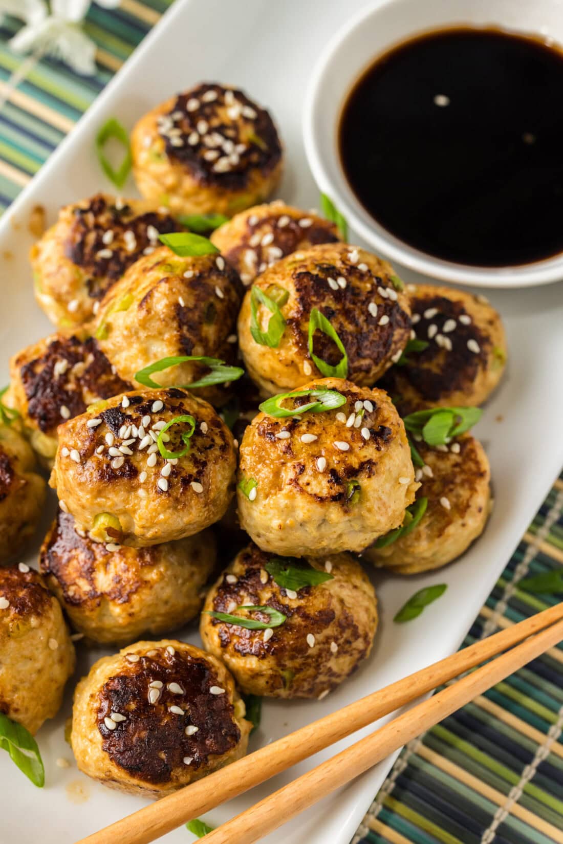 Close up photo of Asian Meatballs on a platter with a bowl of soy sauce