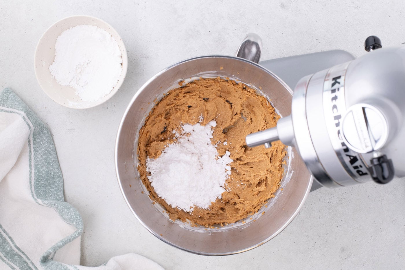 combining powdered sugar with cookie butter and cream cheese mixture in a mixer bowl