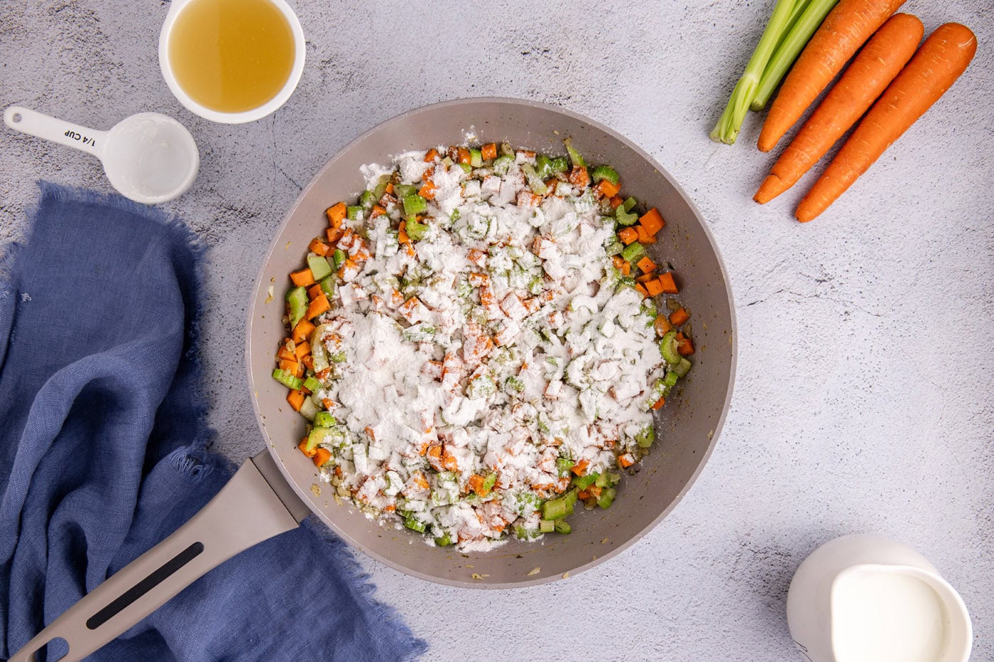 flour sprinkled over veggies in a skillet