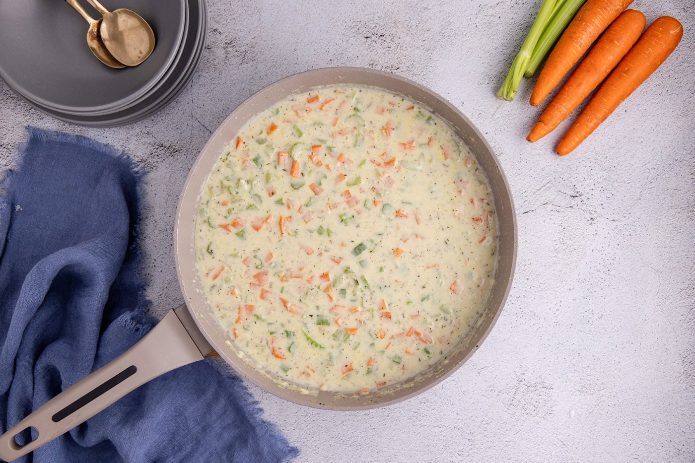 milk and chicken stock added to pot pie mixture in a skillet