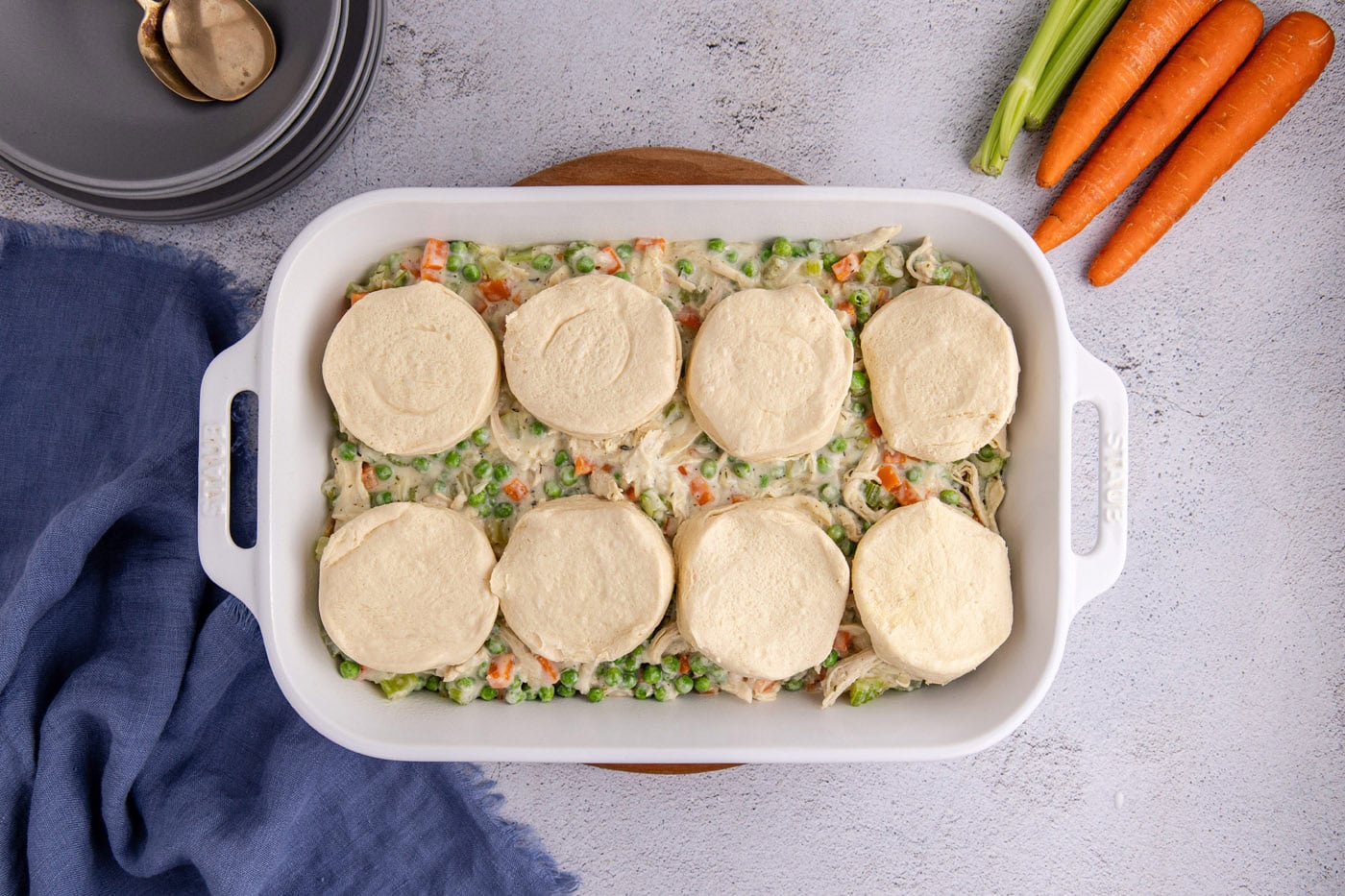 chicken pot pie topped with biscuits in a casserole dish