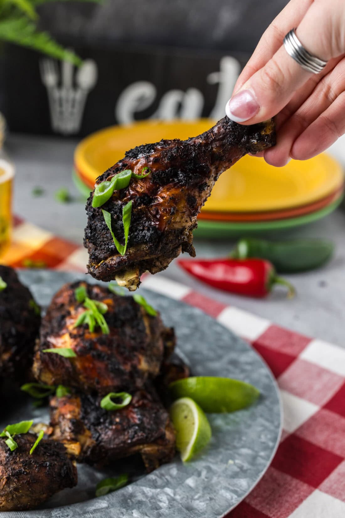 Hand holding up a piece of Jerk Chicken