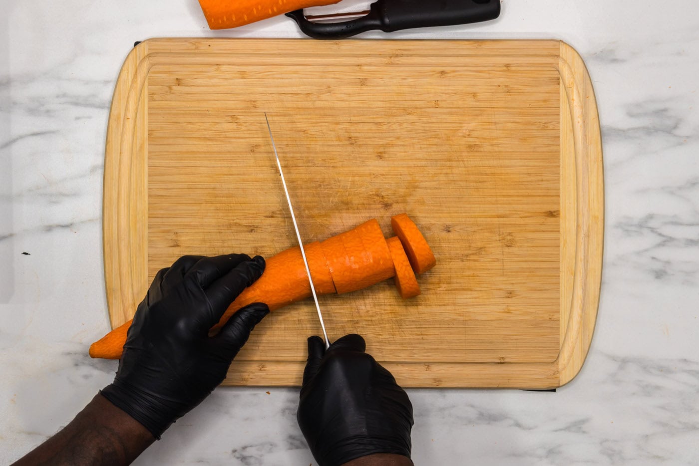 slicing carrot into coins on a cutting board