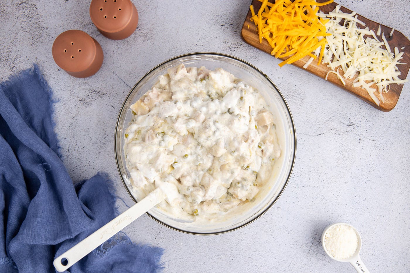 turkey tetrazzini sauce mixture in a mixing bowl with a rubber spatula