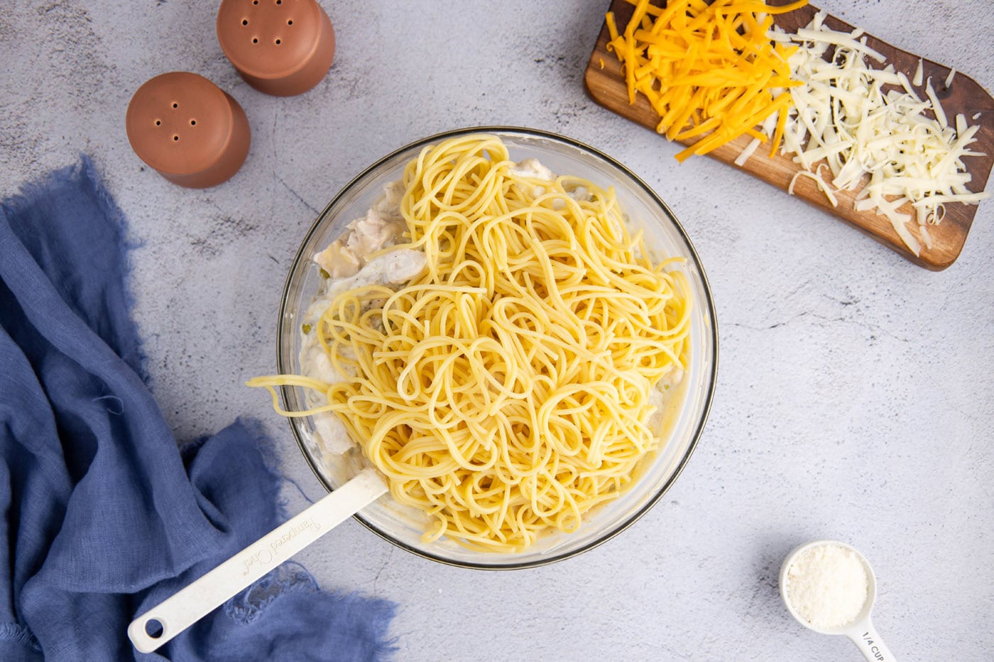 spaghetti noodles added to tetrazzini mixture in a bowl