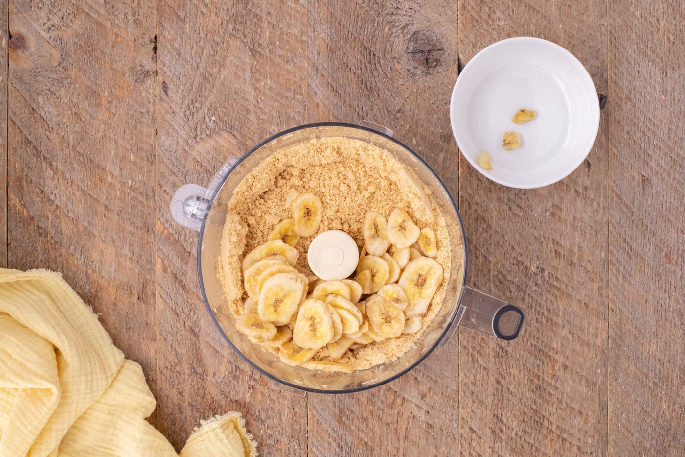 banana chips on top of crushed oreo cookie crumbs in a food processor