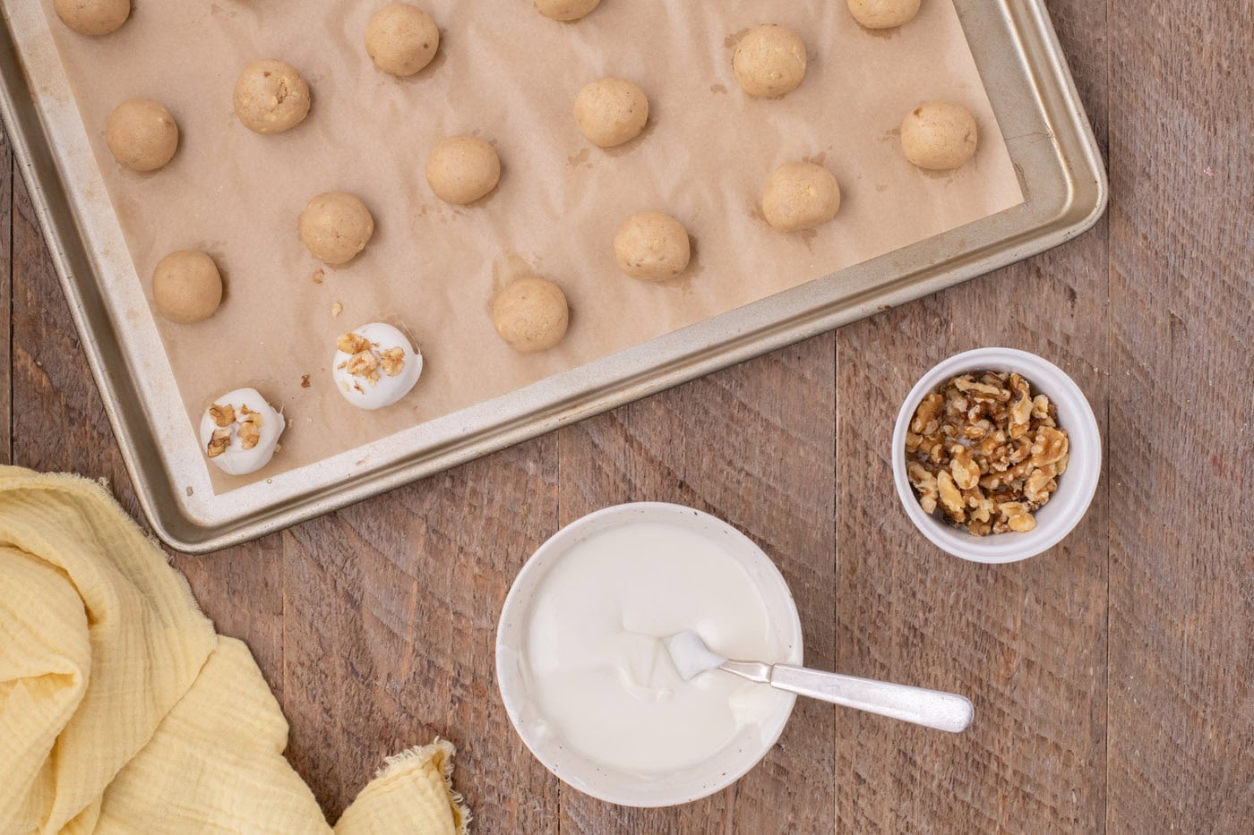 white chocolate coated banana truffles with walnuts on a baking sheet