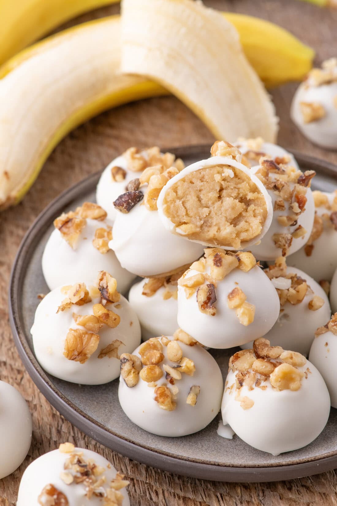 Banana Truffles stacked on a plate with one cut in half