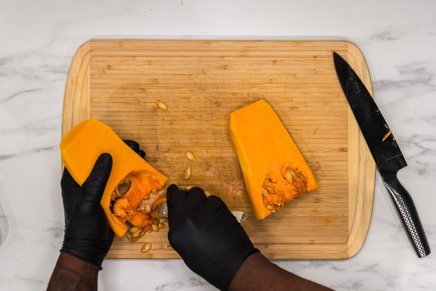 deseeding butternut squash on a cutting board