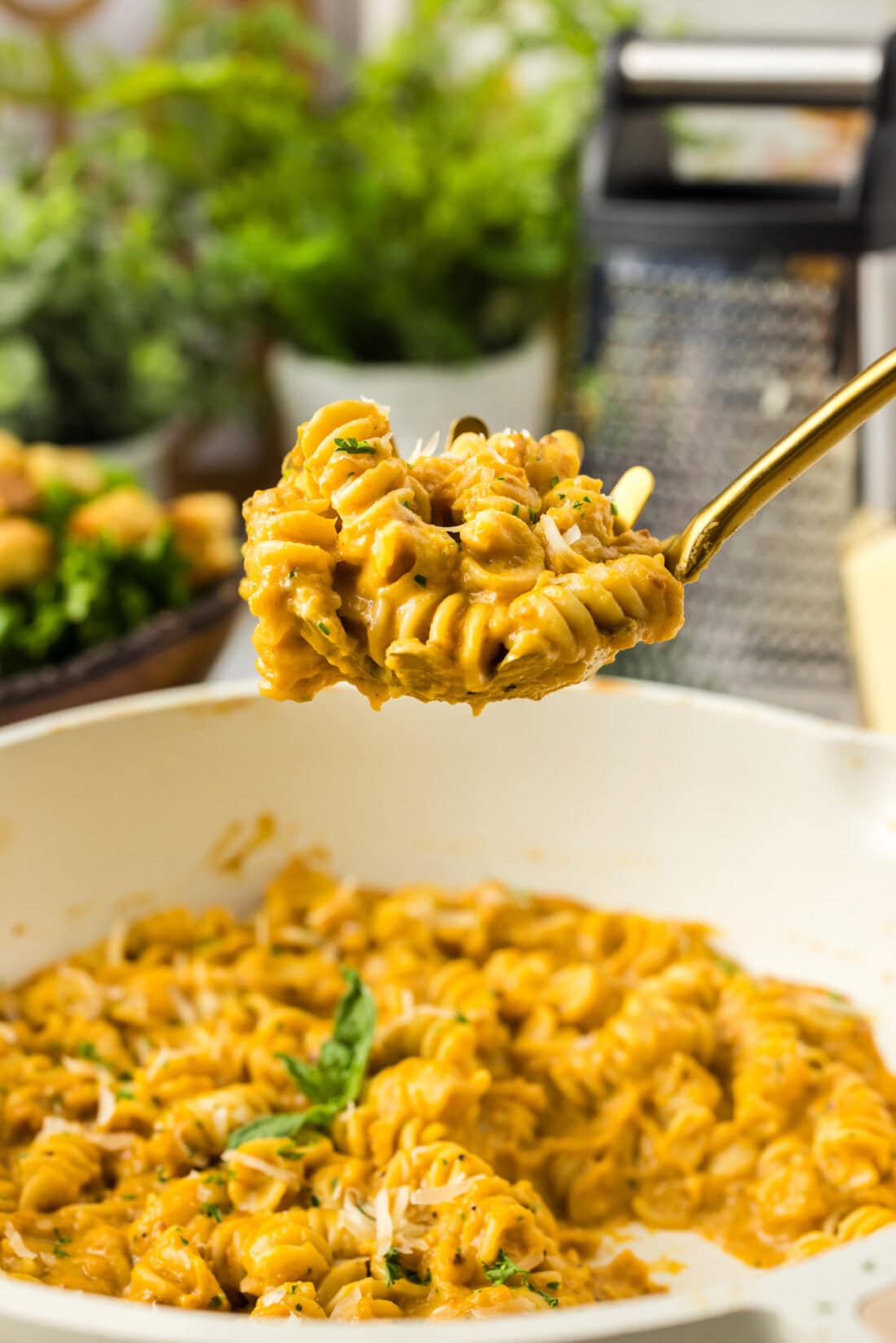 Serving spoon full of Butternut Squash Pasta held above a skillet