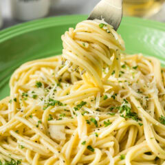 Garlic Butter Pasta twirled on a fork held above a plate of Garlic Butter Pasta