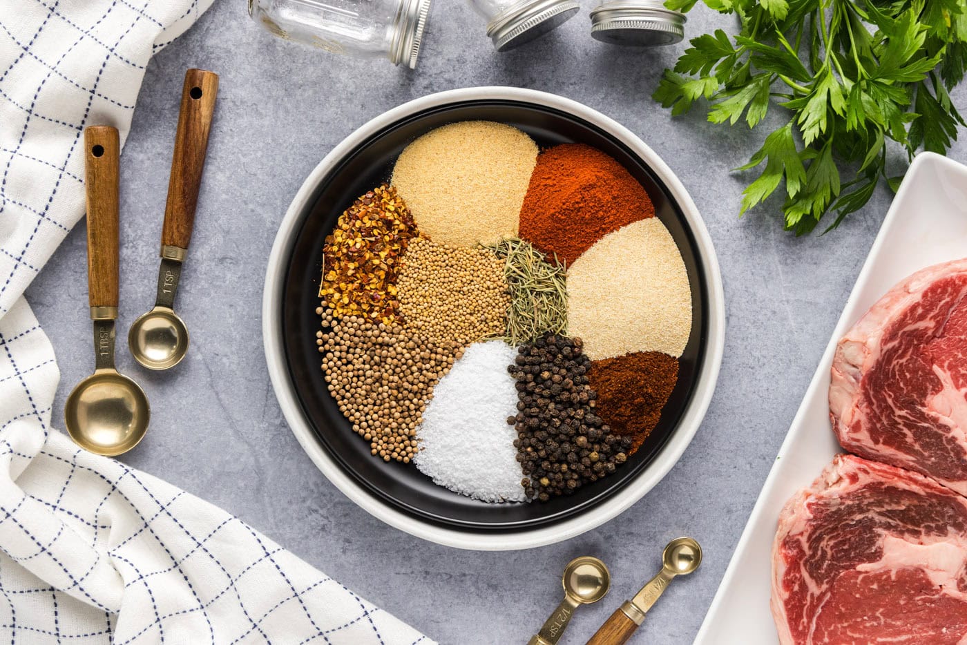 spices and herbs spooned into a bowl neatly