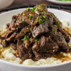 Close up photo of Instant Pot Beef Tips and Gravy served over mashed potatoes