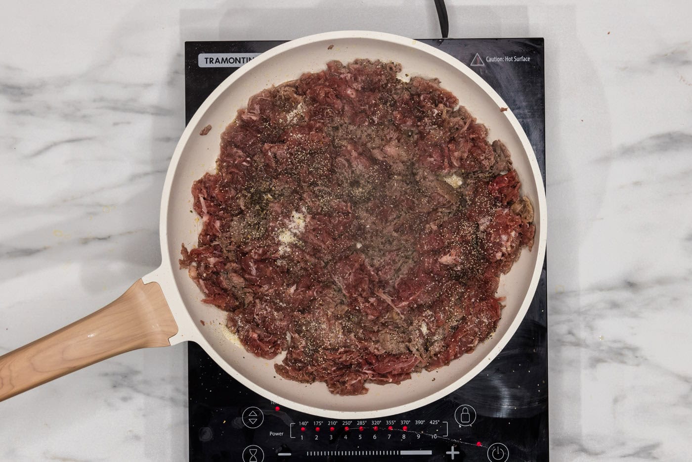 browned shaved beef in a skillet