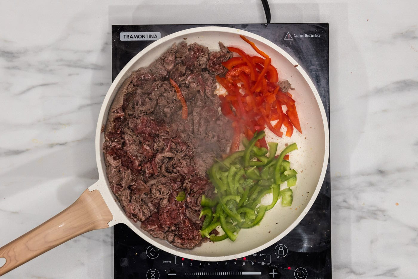 bell peppers in a skillet with shaved beef