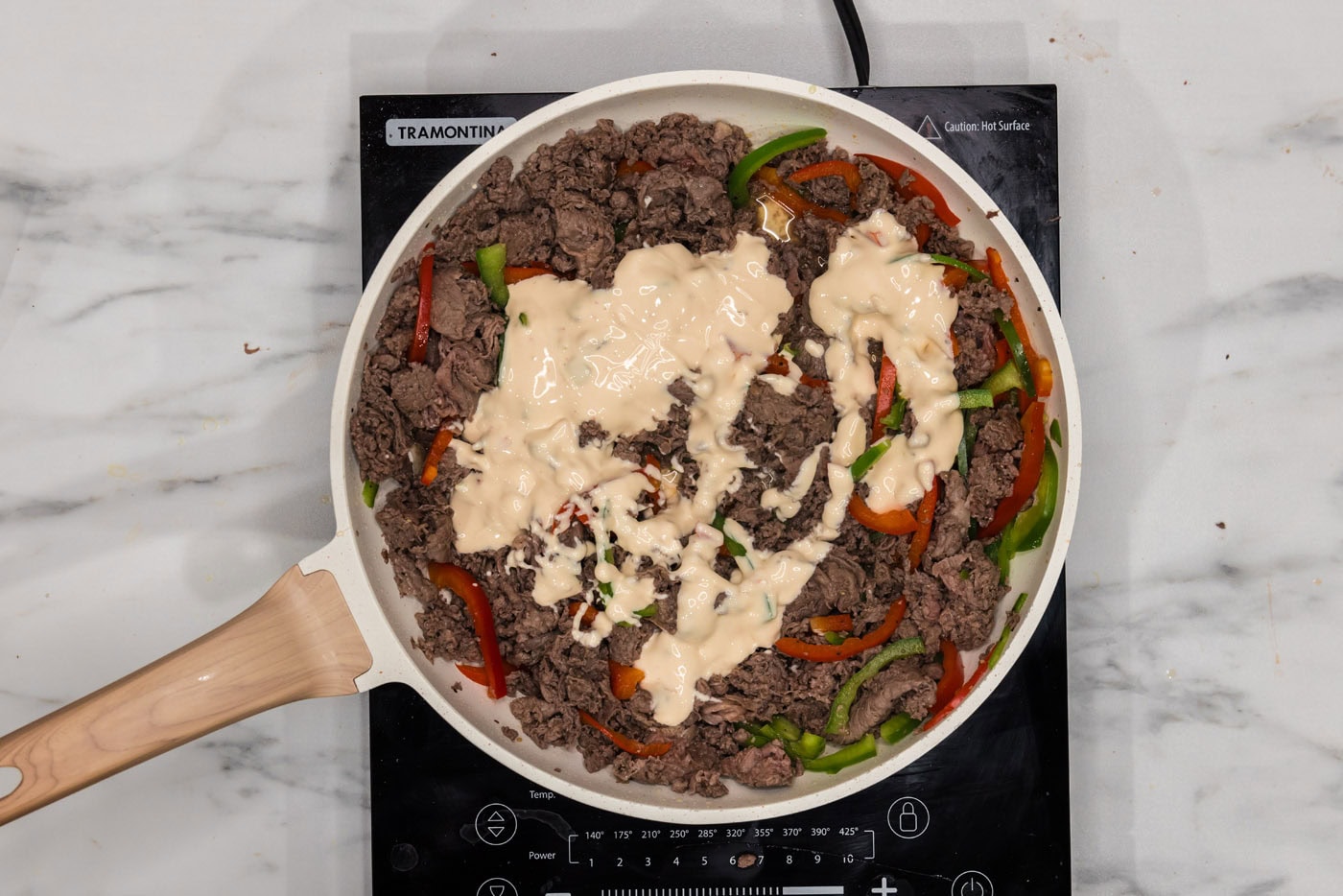 queso blanco added to skillet with bell peppers and beef