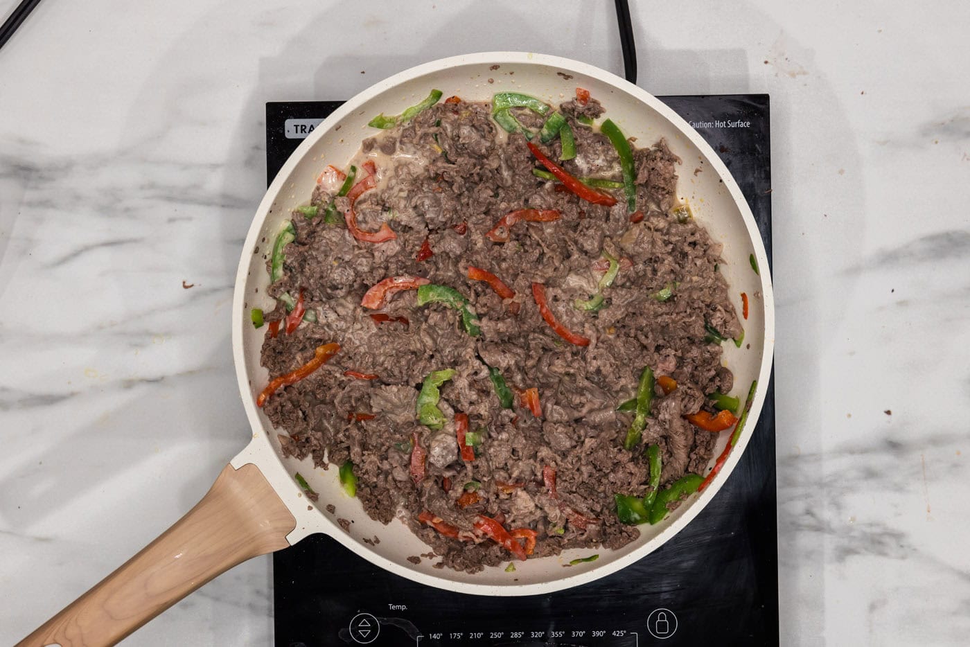 bell peppers, beef, and queso in a skillet