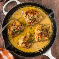 Skillet Chicken Thighs in a skillet with a spoon to the side