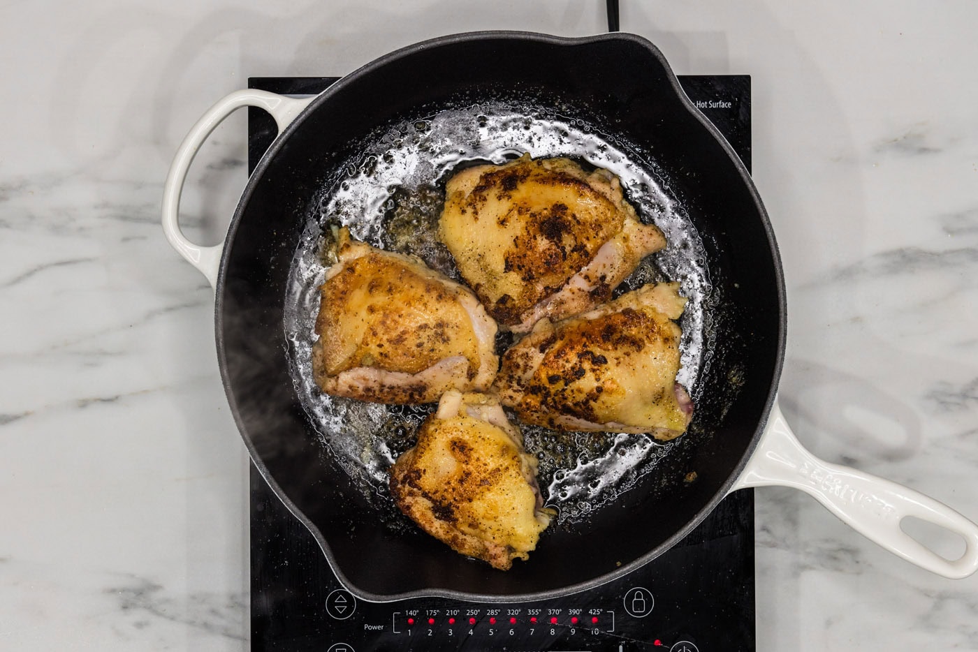 browned chicken thighs in a skillet