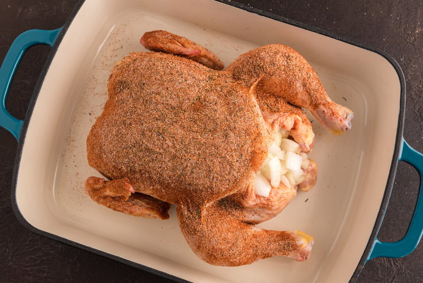 whole chicken rubbed with seasonings and stuffed with onions