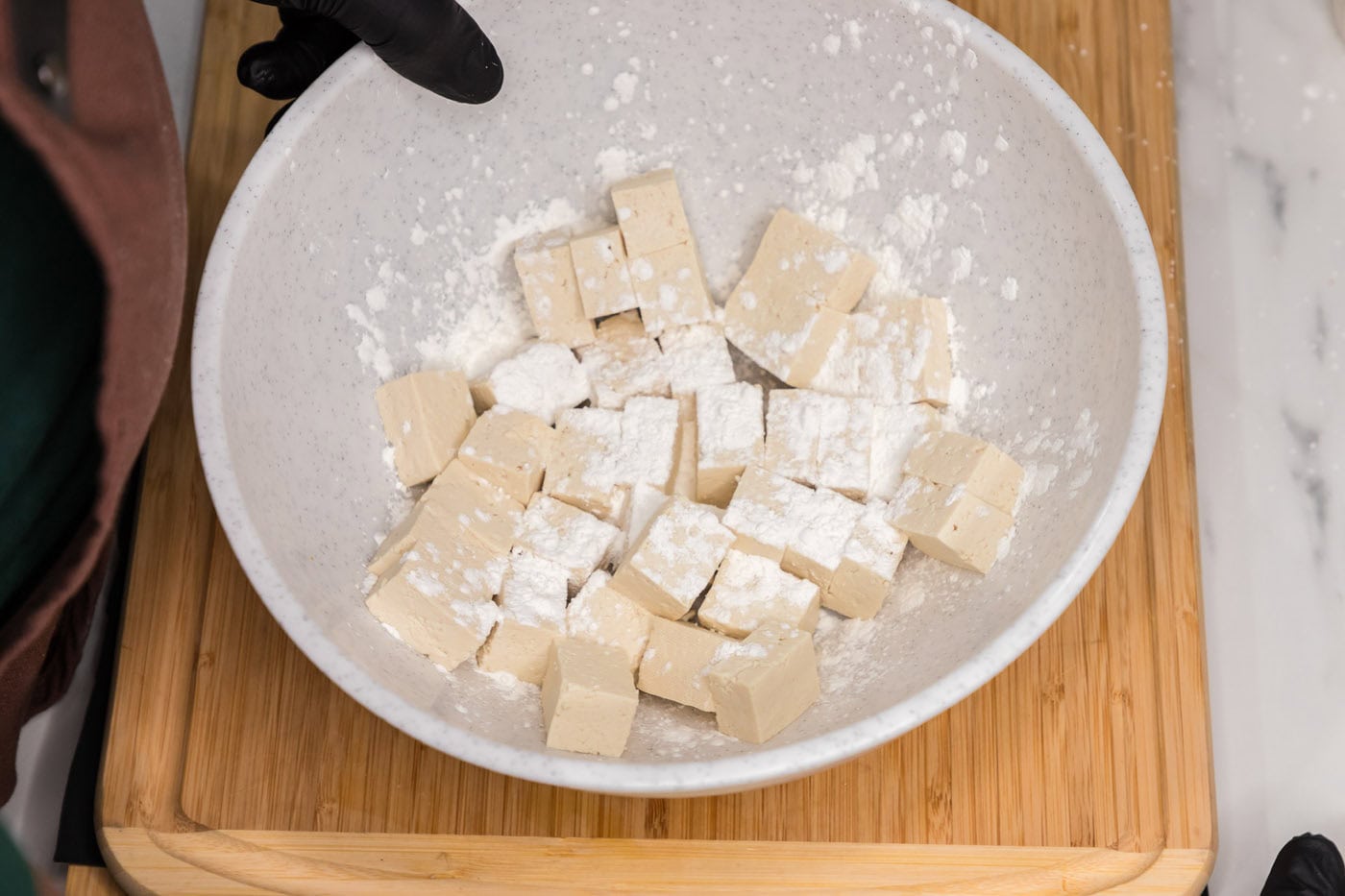 cubed tofu with cornstarch on top in a bowl