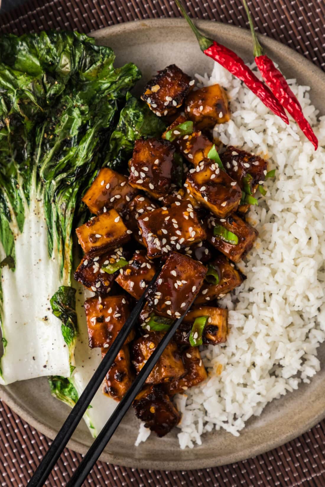 Close up photo of Spicy Tofu on a plate with rice and chopsticks