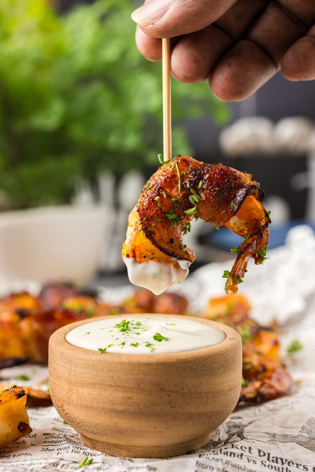 Air Fryer Bacon Wrapped Shrimp on a toothpick dipped in ranch