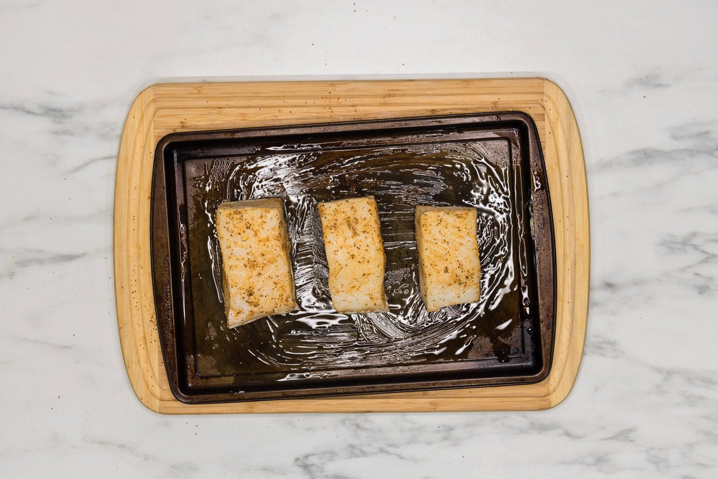 chilean sea bass filets on a baking sheet