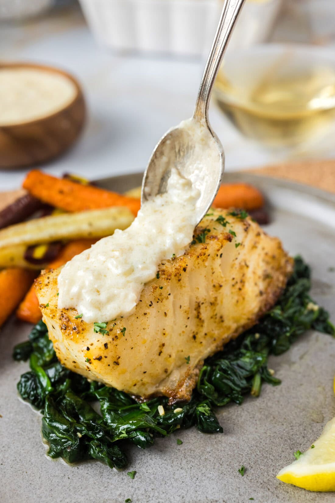 Beurre Blanc Sauce being spooned over Baked Chilean Sea Bass